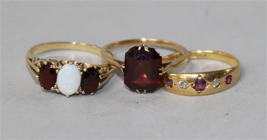 A 9ct gold, opal and garnet ring, scrolled carved mount, an 18ct gold, ruby and diamond gypsy-set ring and another 9ct gold ring